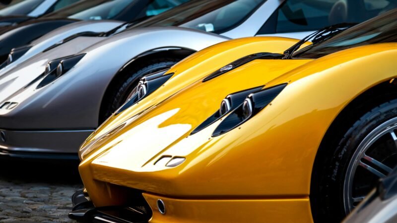 A lineup of Pagani hypercars displayed outdoors showcasing luxury and style.